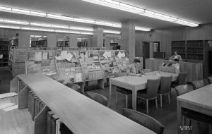People sitting at tables in library.