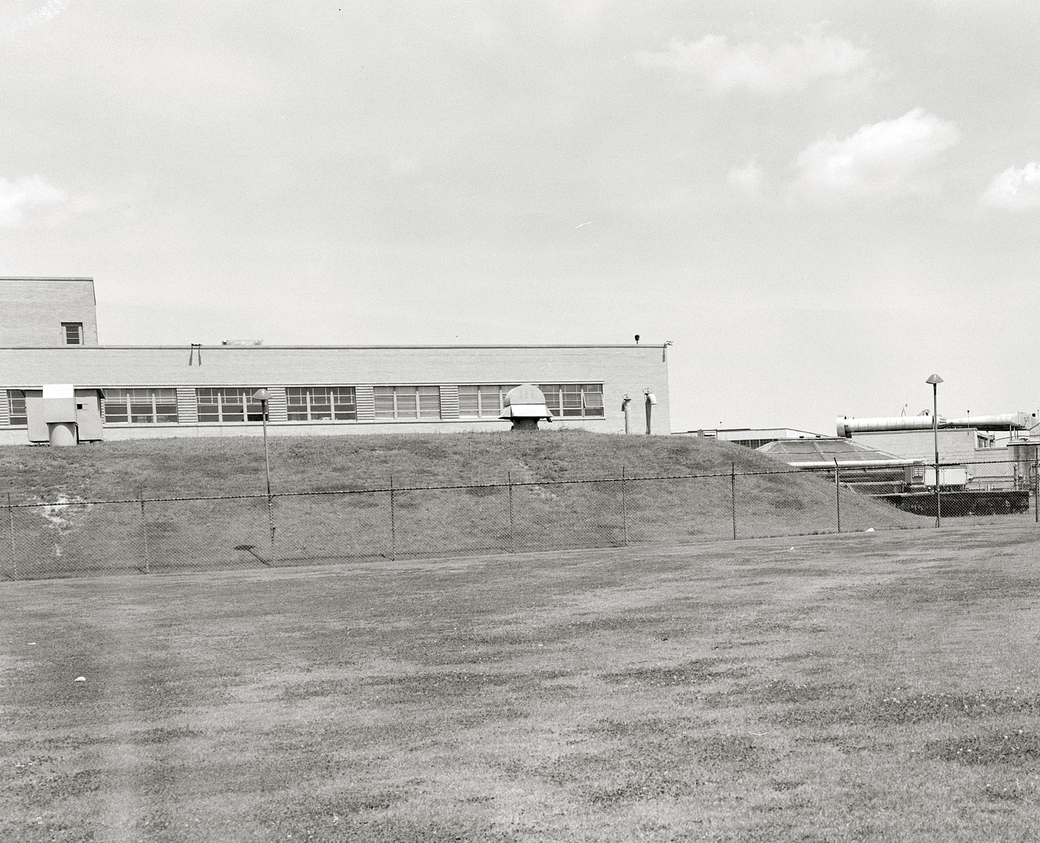 Grassy mound in front of building.