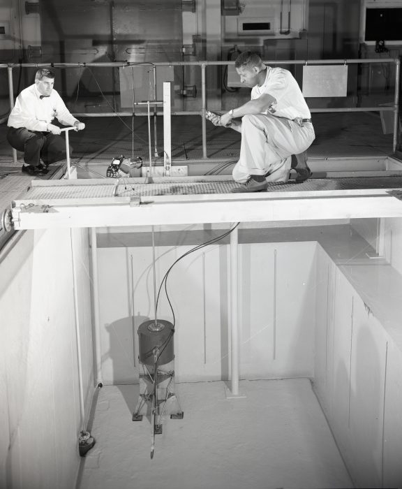Two men looking down into test pool.