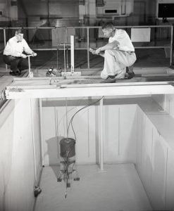 Two men looking down into test pool.