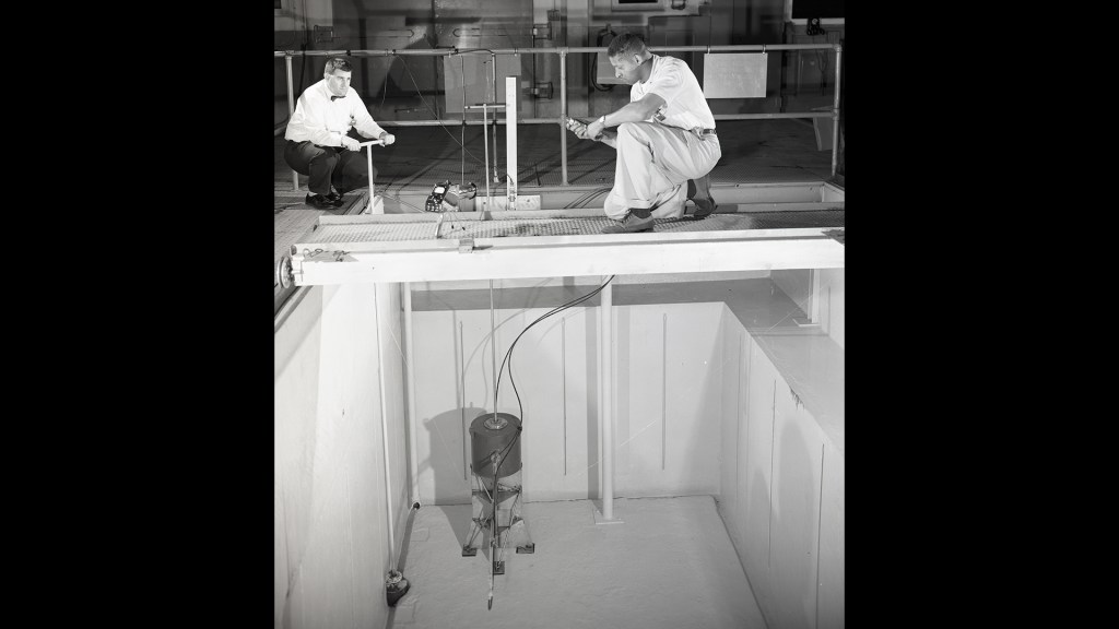 Two men looking down into test pool.