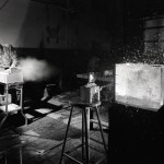 Man firing projectile at glass tank.