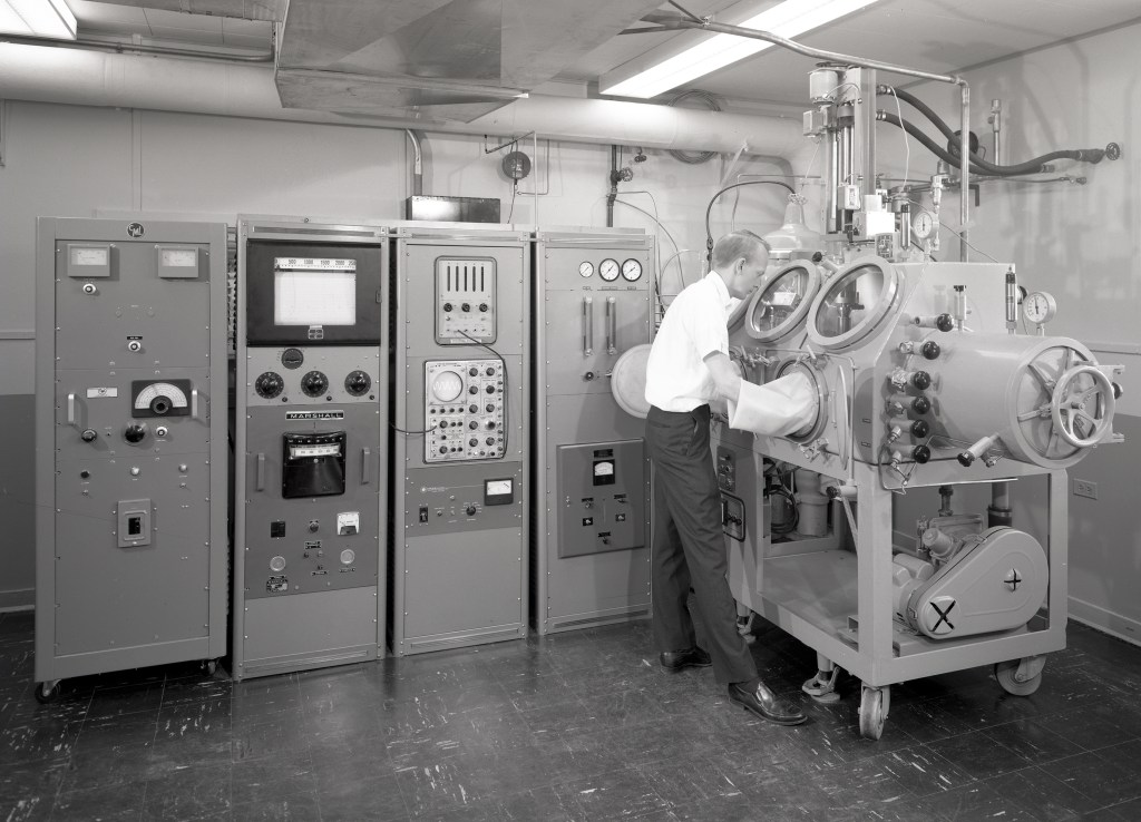 Researcher with hands in glovebox of cavitation facility