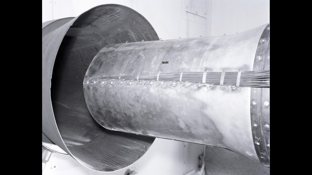 Engine nozzle shroud entering duct.