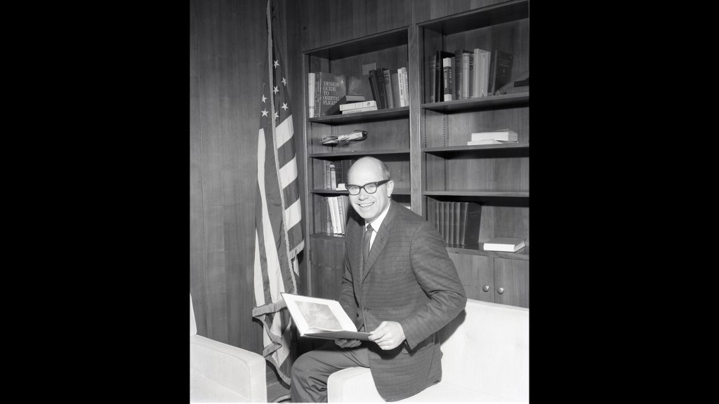 Man sitting in front of bookcase.