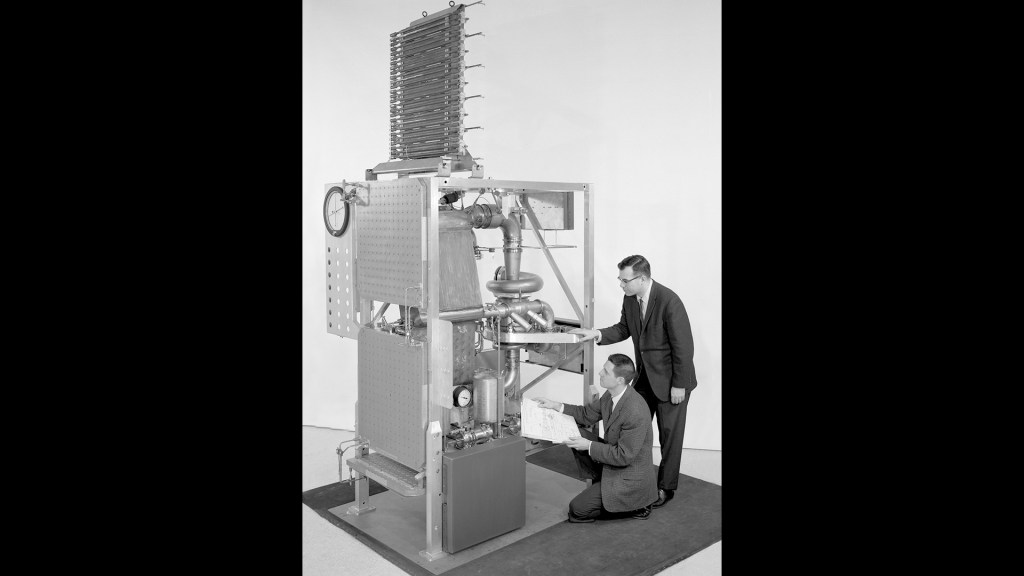Two engineers examine Brayton rig assembly.