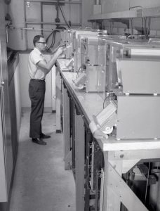 Man examining small furnaces on table.