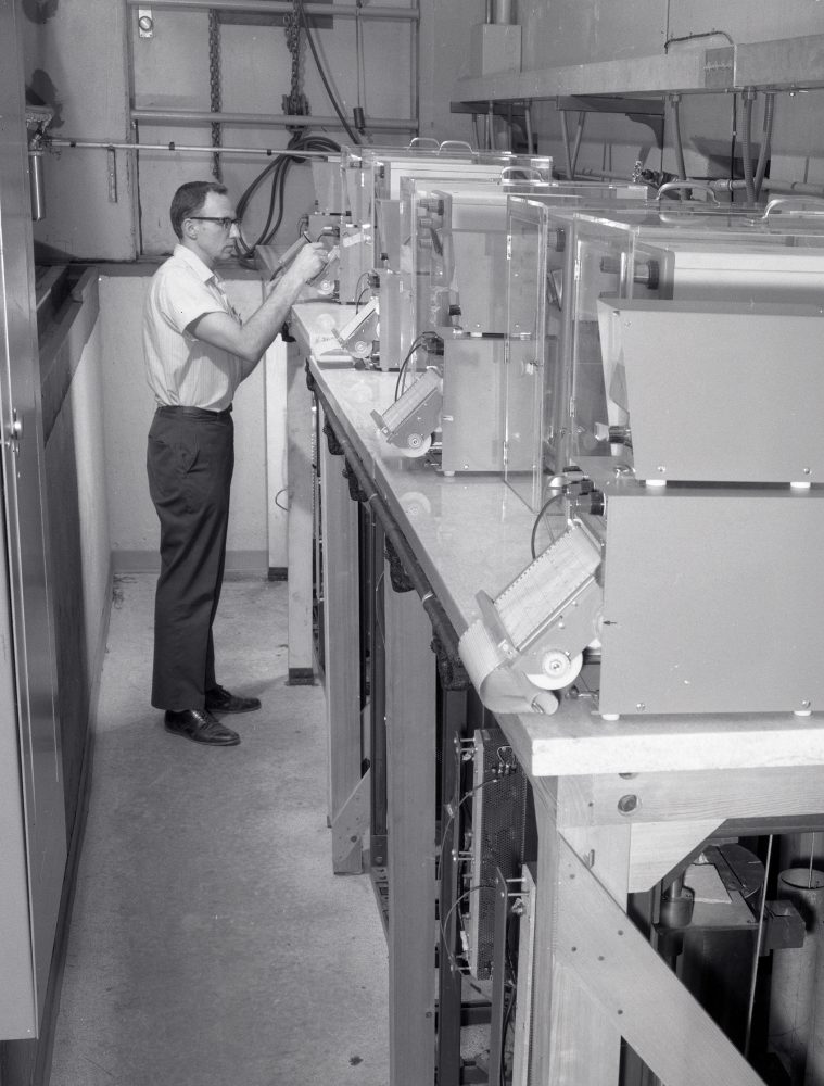 Man examining small furnaces on table.