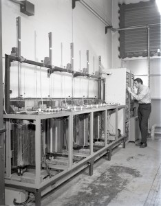 Researcher examines materials tests rigs.