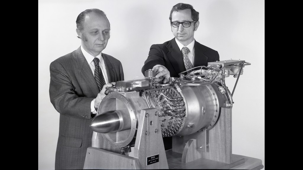 Two men looking at small engine.