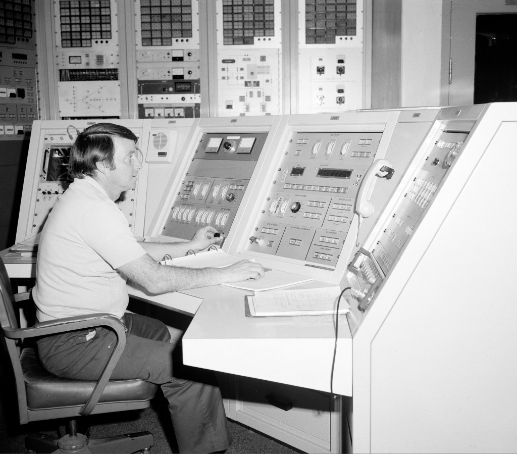 Man sitting at control panel.