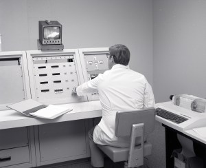 Doctor sitting at console.