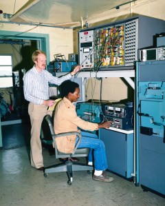 Two men at control panel.