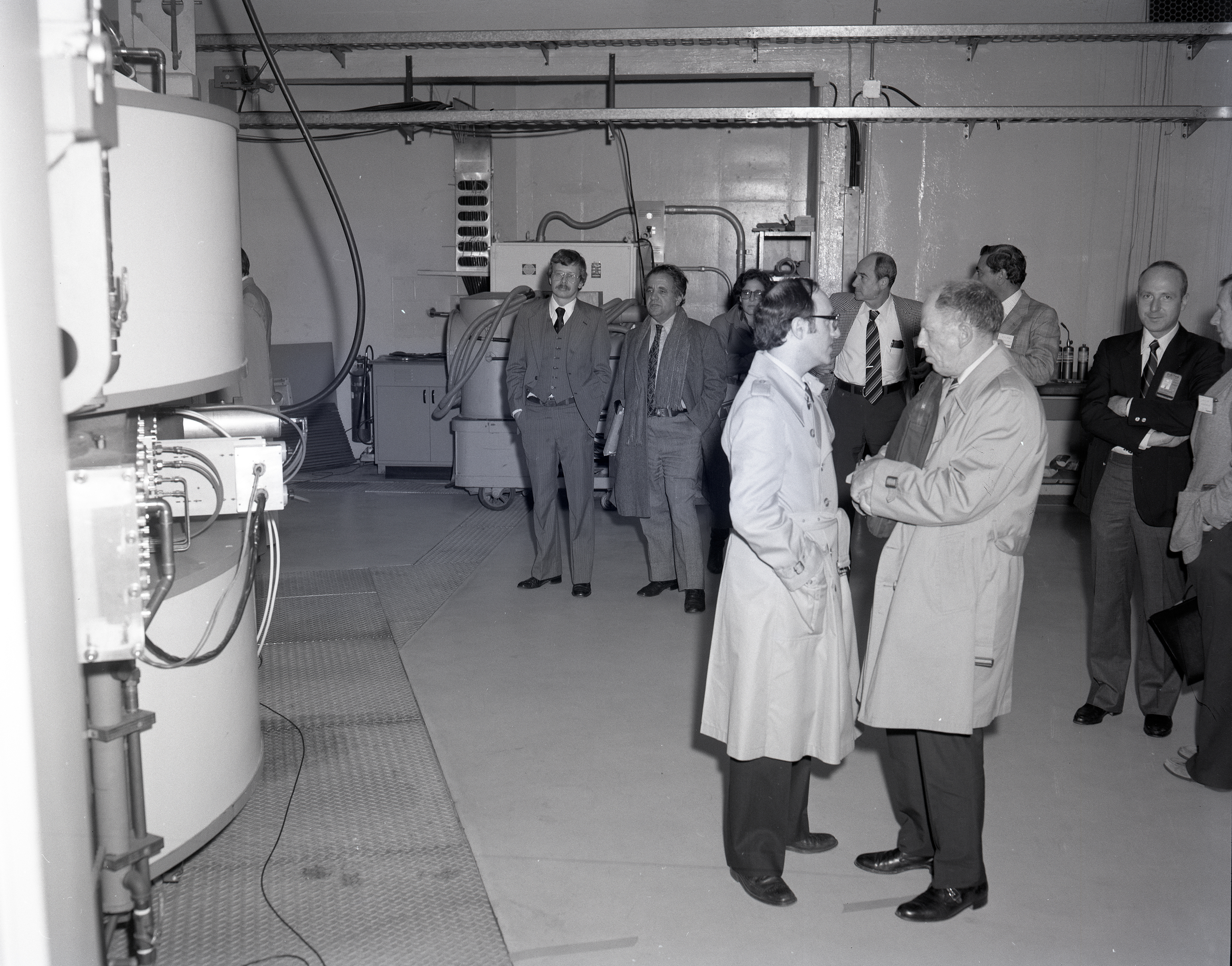 Men standing in control room.