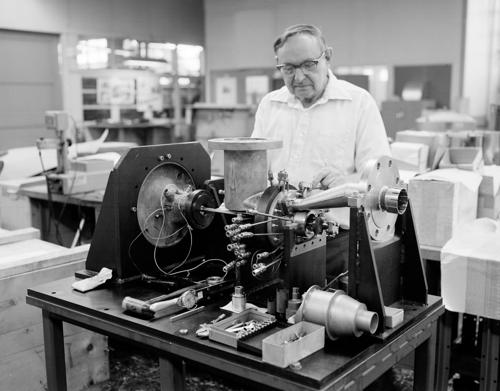 Man working on table-mounted rig.