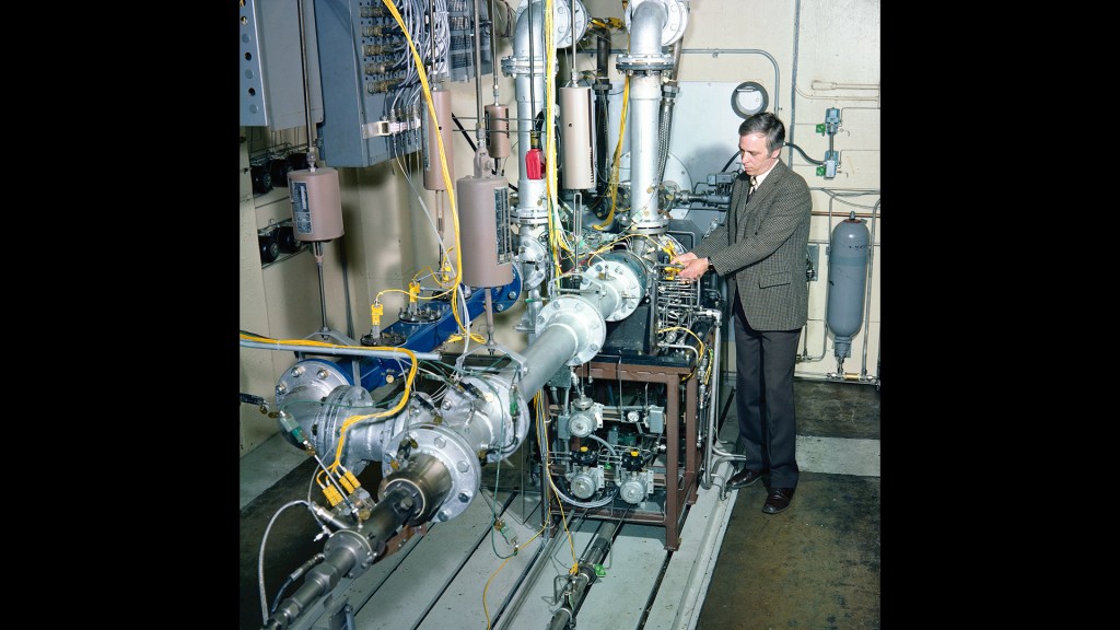 Man examining rig in test cell.