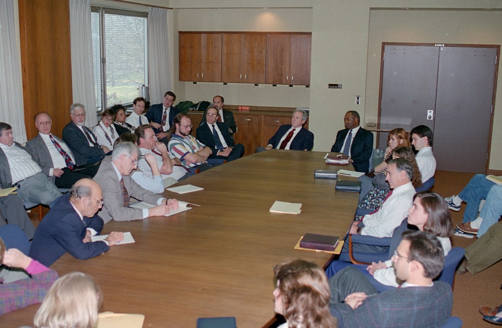 Group seated around table in conference room.