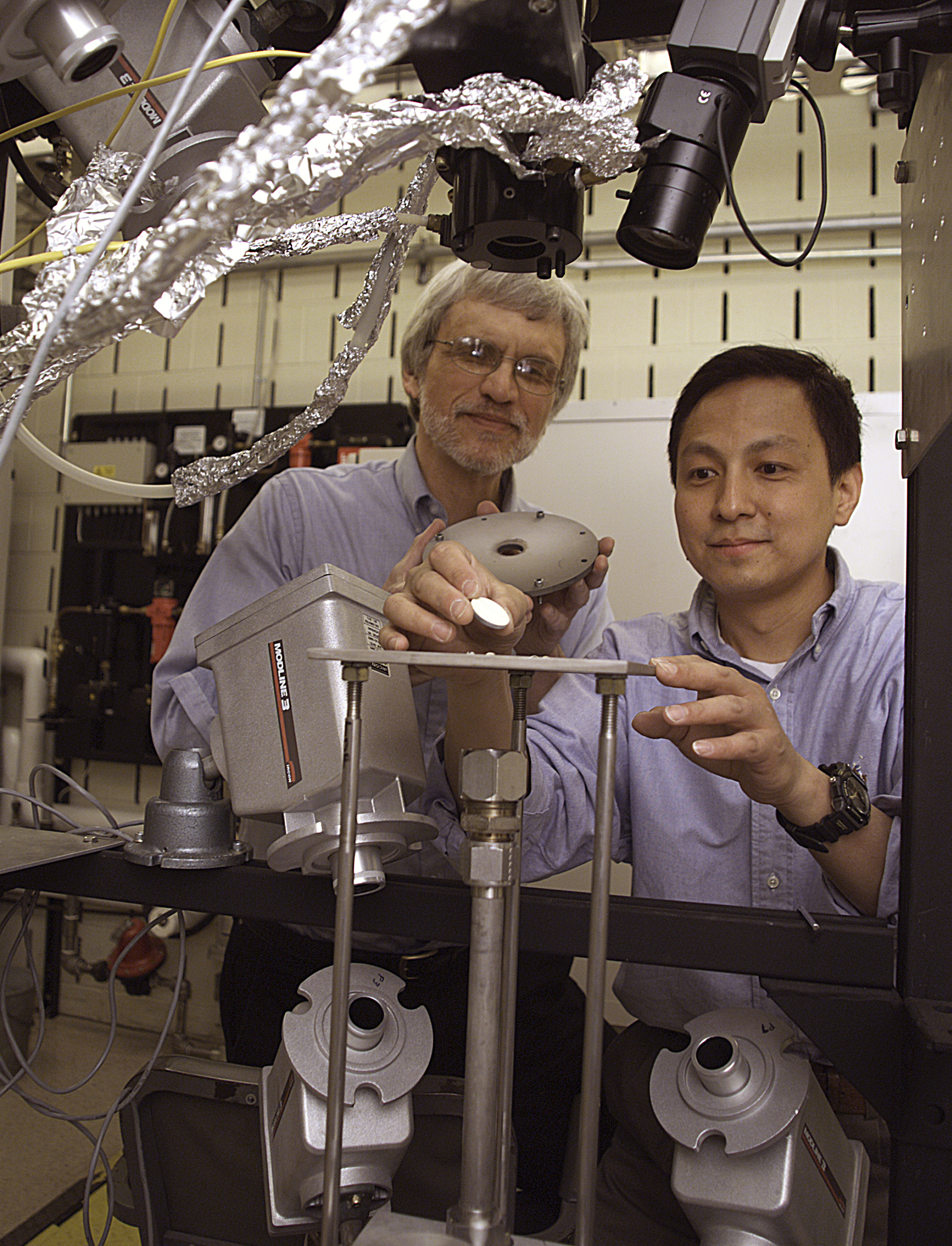 Two men examining test specimen.