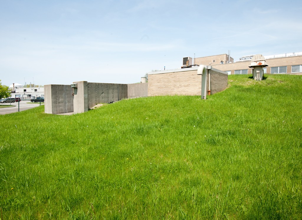 Grassy mound with building.