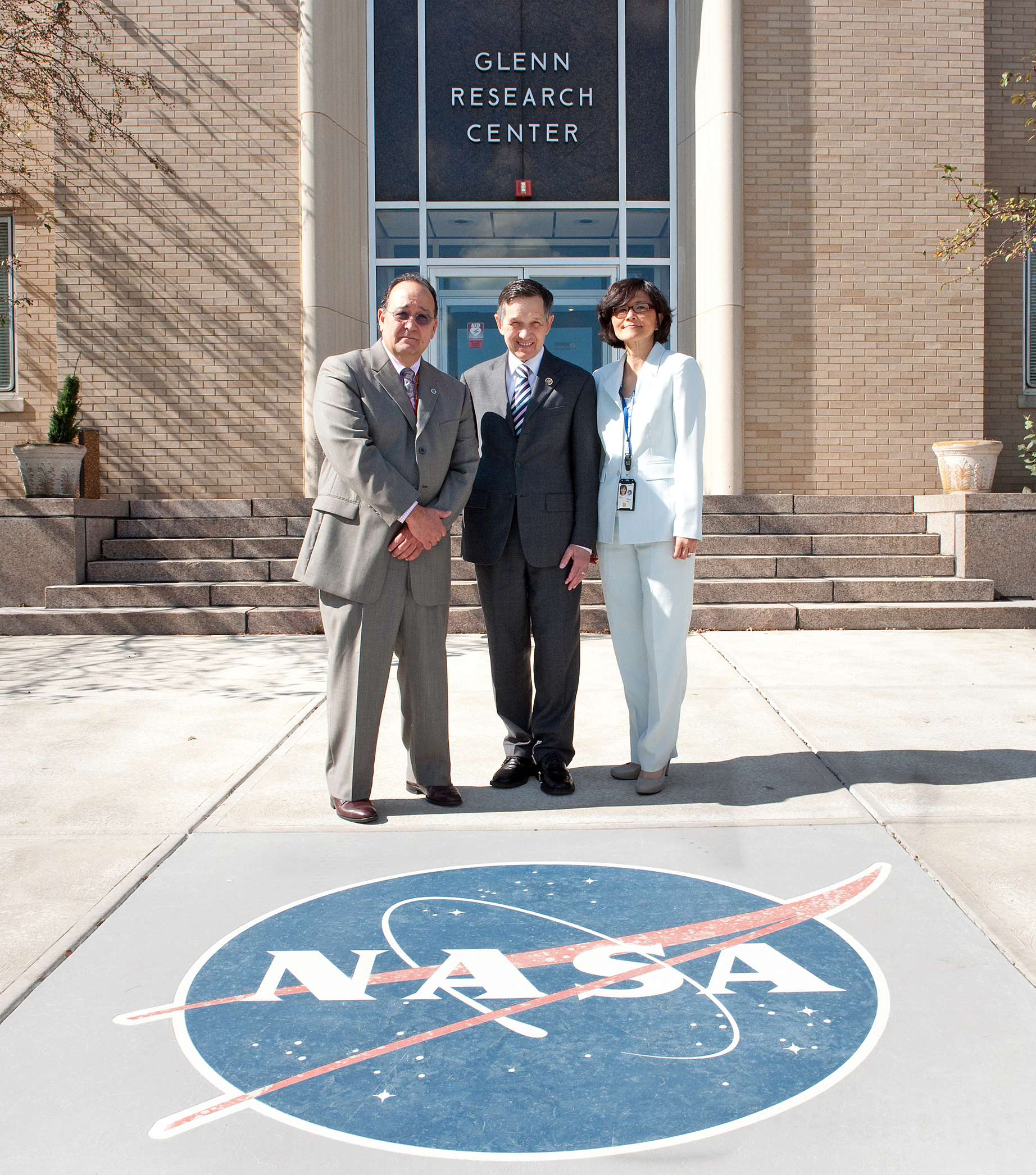 Two men and woman standing in front of building.