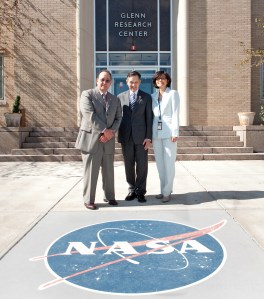 Two men and woman standing in front of building.