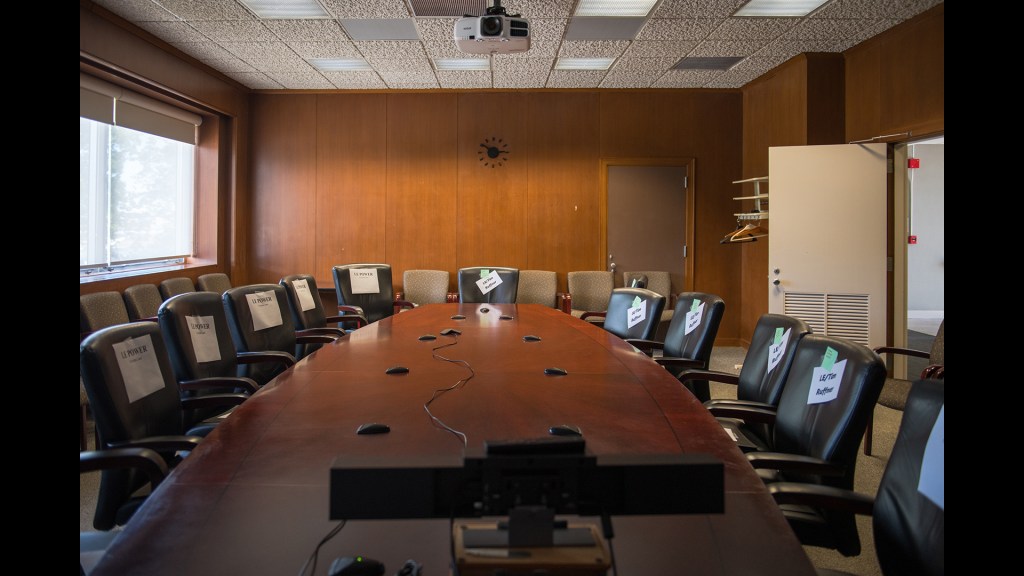 View of the conference room with its large table and numerous black leather chairs