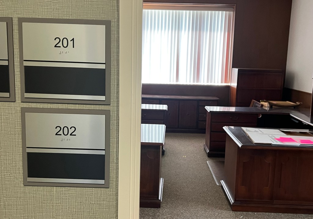 View into office with nameplates on wall.