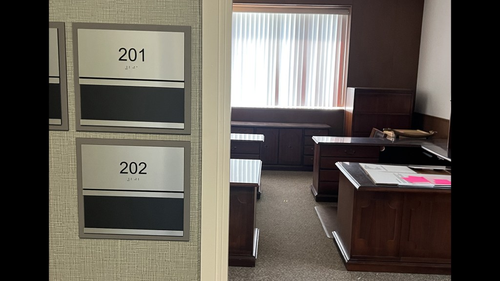 View into office with nameplates on wall.