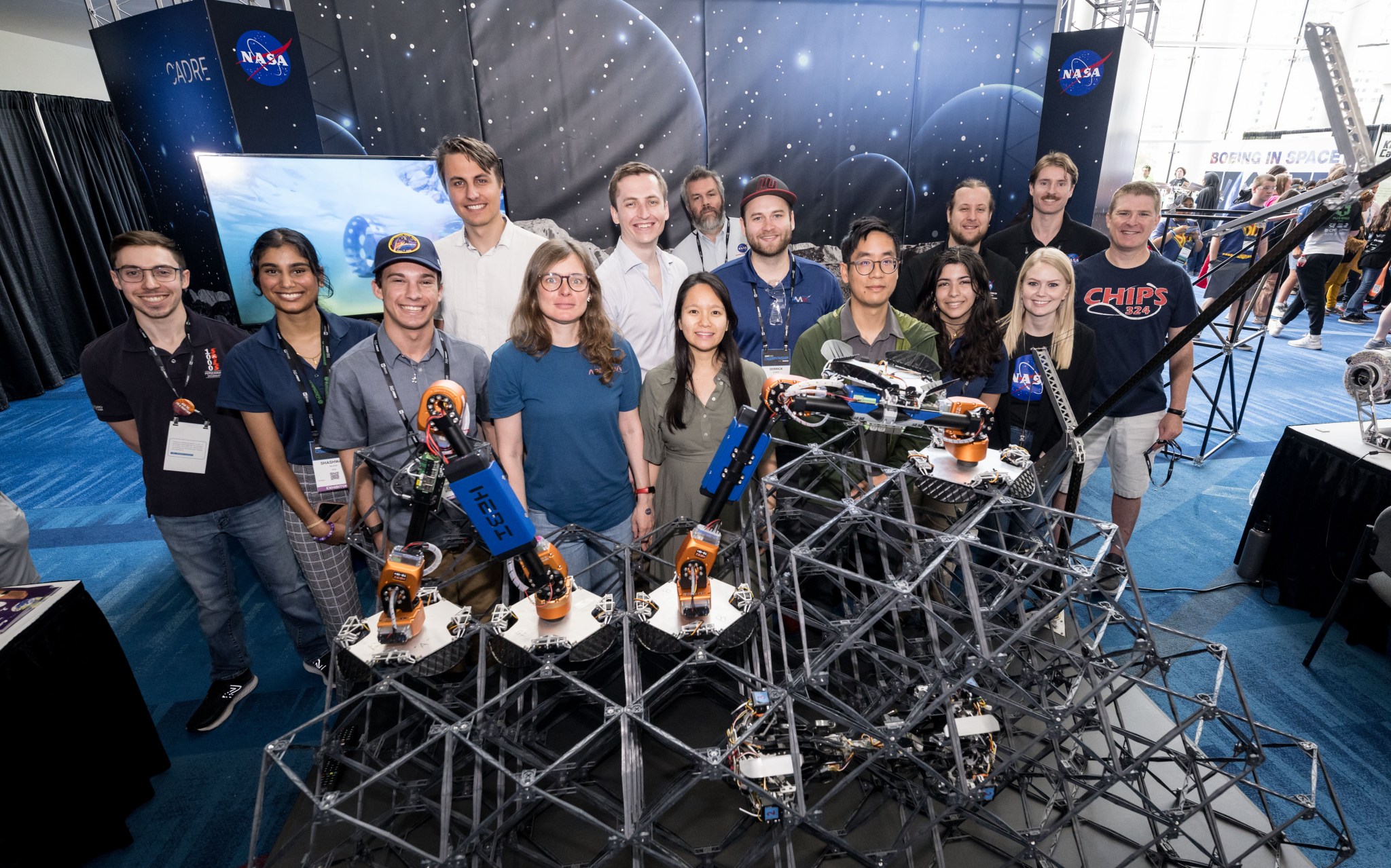 A group of people pose in front of a large structure