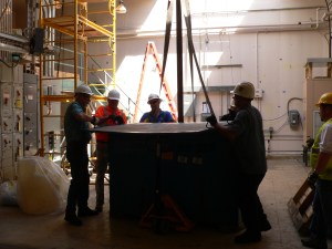 Men prepare load for crane lift.