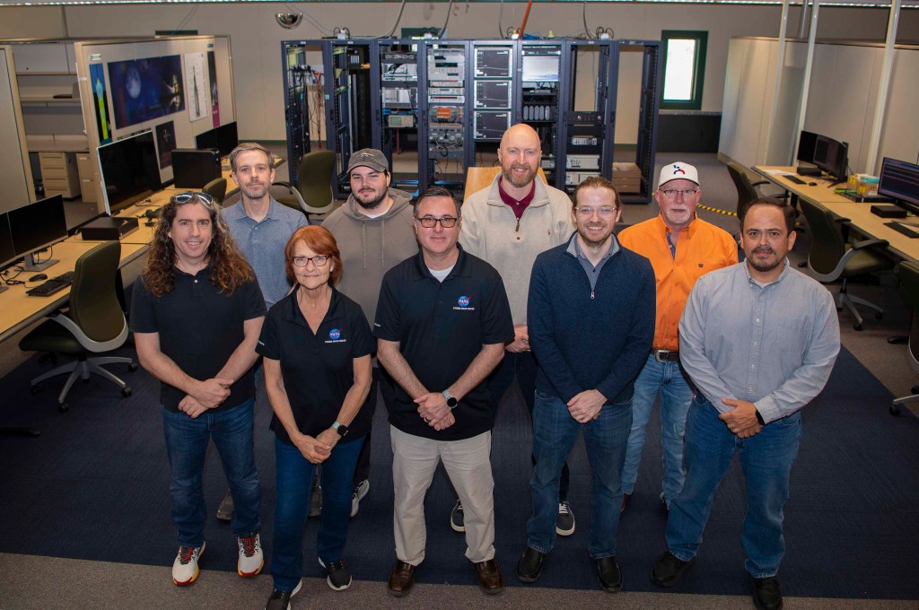 A blended team of NASA personnel and contractors pose for a group photo