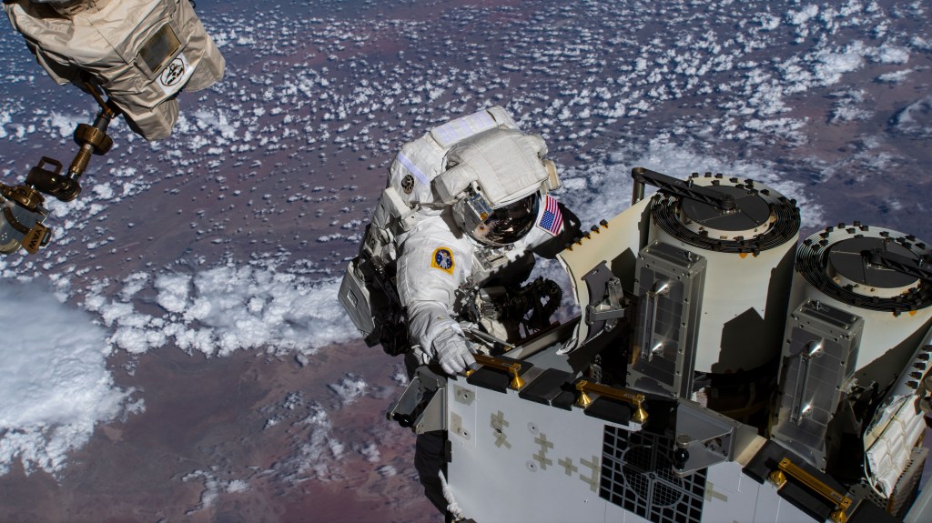 Expedition 68 Flight Engineer and NASA spacewalker Josh Cassada prepares a roll-out solar array for its deployment on the International Space Station's Port-4 truss segment as the orbiting lab flew 262 miles above the Atlantic Ocean off the coast of Namibia.