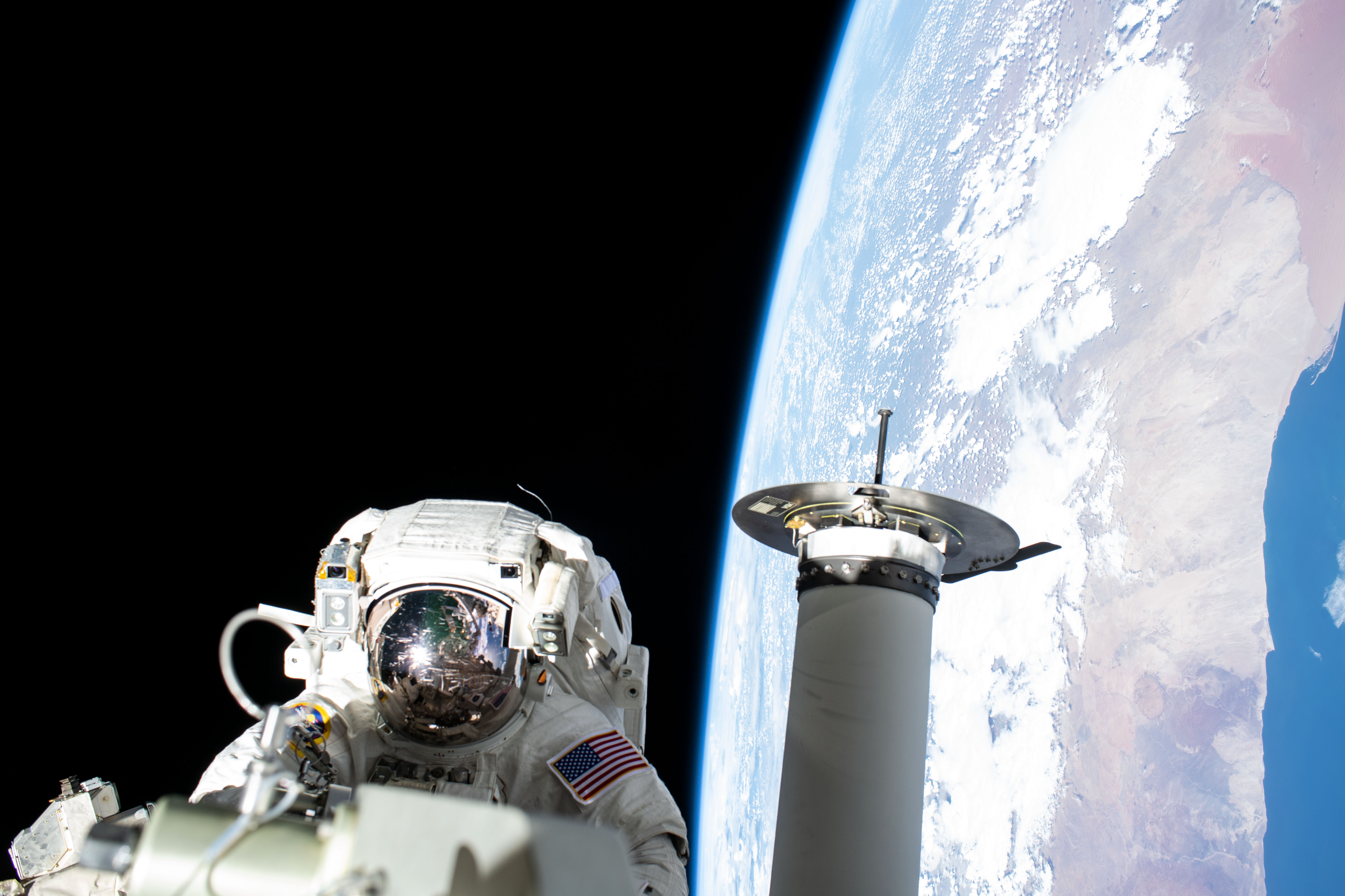 Expedition 68 Flight Engineer and NASA spacewalker Josh Cassada prepares a roll-out solar array for its deployment on the International Space Station's Port-4 truss segment as the orbiting lab flew 262 miles above the Atlantic Ocean off the coast of Namibia.