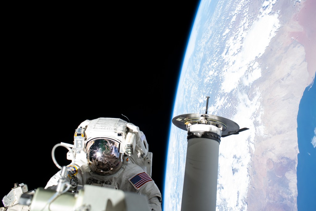 Expedition 68 Flight Engineer and NASA spacewalker Josh Cassada prepares a roll-out solar array for its deployment on the International Space Station's Port-4 truss segment as the orbiting lab flew 262 miles above the Atlantic Ocean off the coast of Namibia.