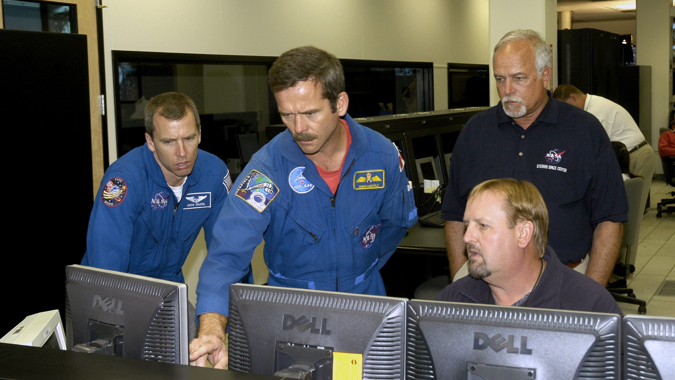 NASA astronaut Drew Feustal, far left, and Canadian Space Agency astronaut Chris Hadfield converse with engineers in the NASA Stennis Test Control Center