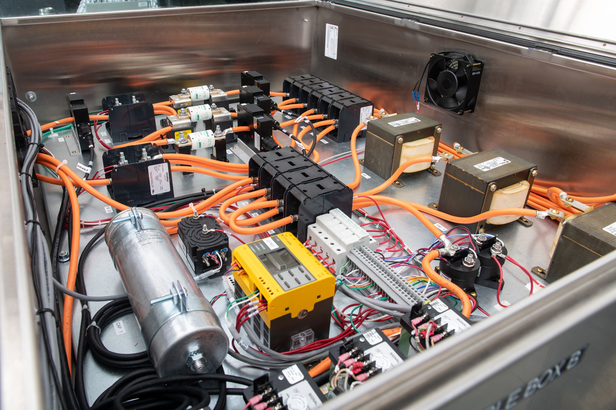 The inside of a testing rig box displaying various colored wires, cables, and devices.