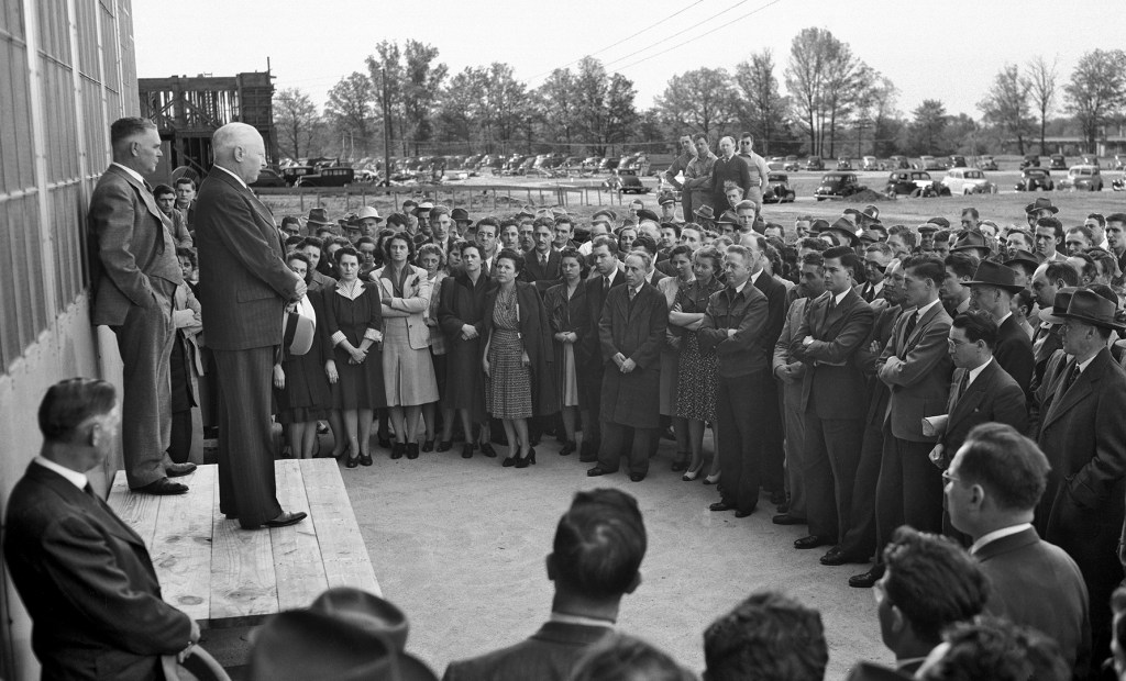 Two men on platform addressing crowd.