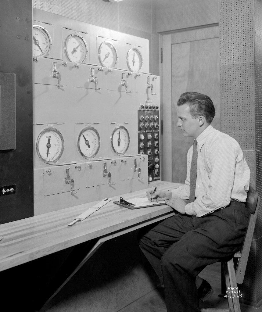 Researcher sits at Altitude Wind Tunnel Control Panel