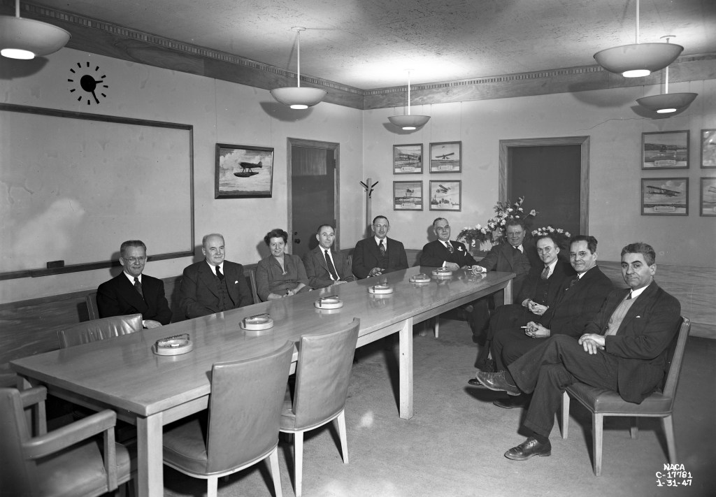 Group of men sitting at long table.