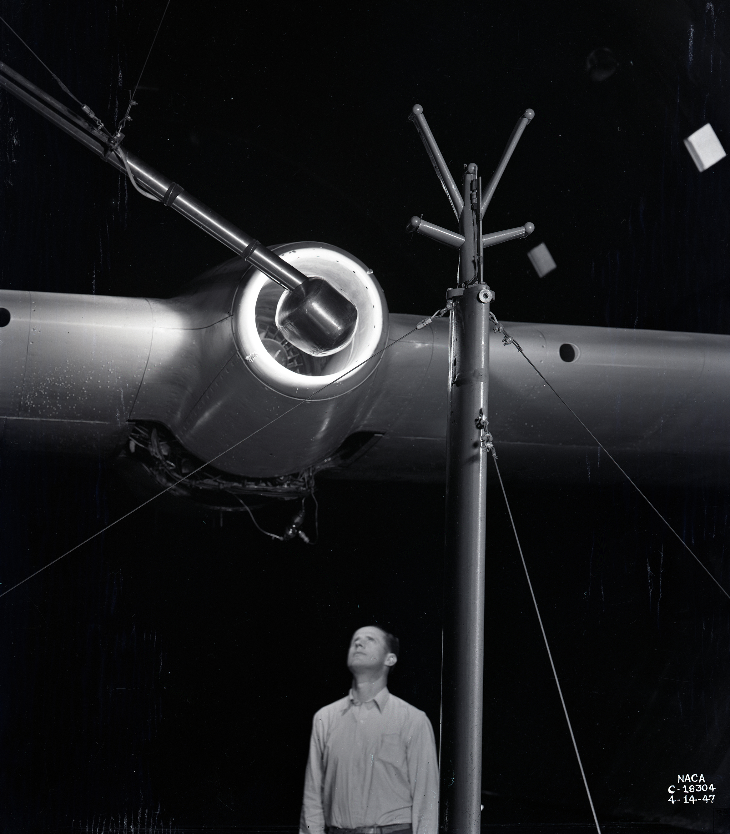 Man looking up at engine on wing.