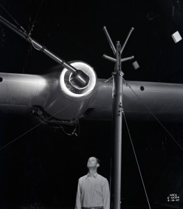 Man looking up at engine on wing.