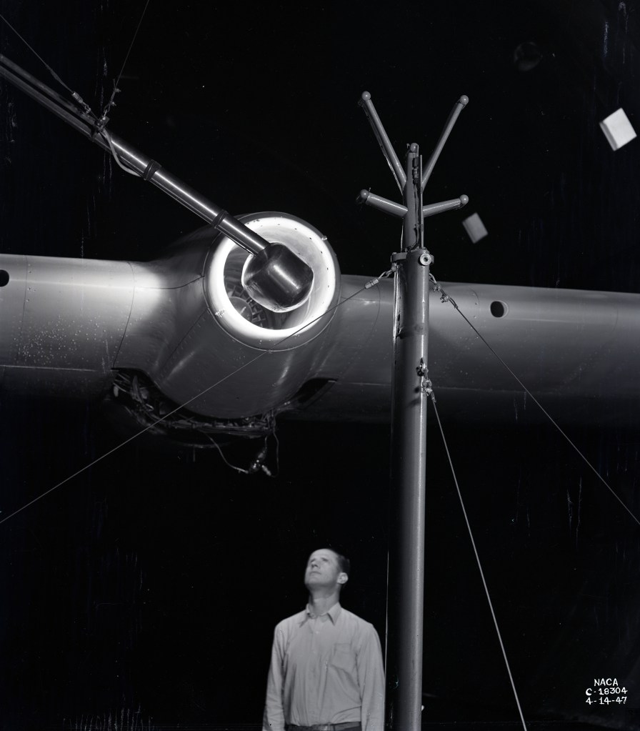 Man looking up at engine on wing.