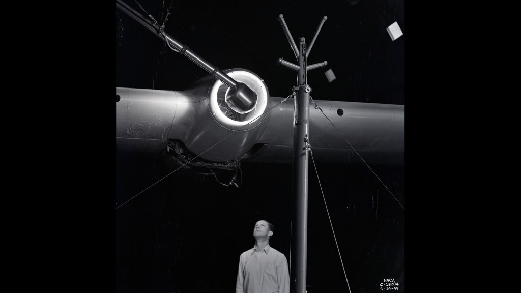 Man looking up at engine on wing.