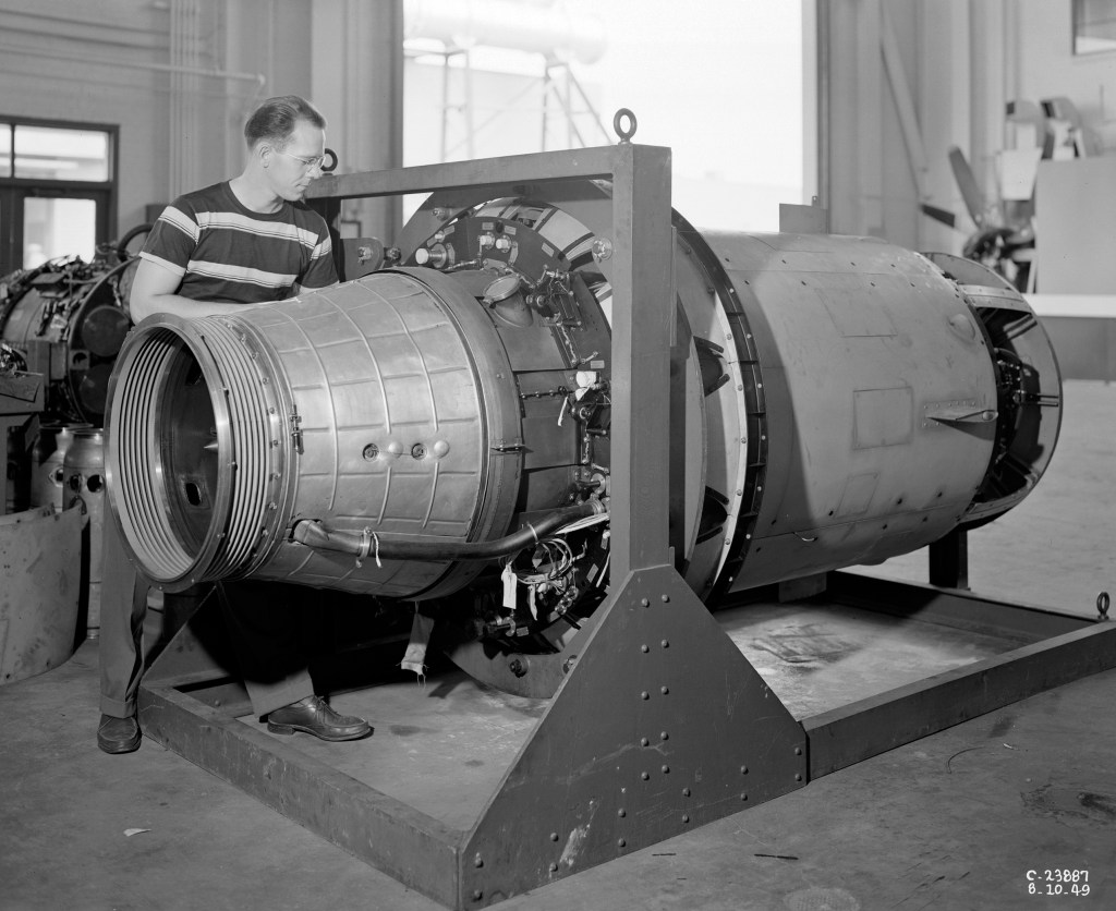 A mechanic examines a Python engine on a stand in the shop area
