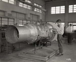Man with engine in shop area.