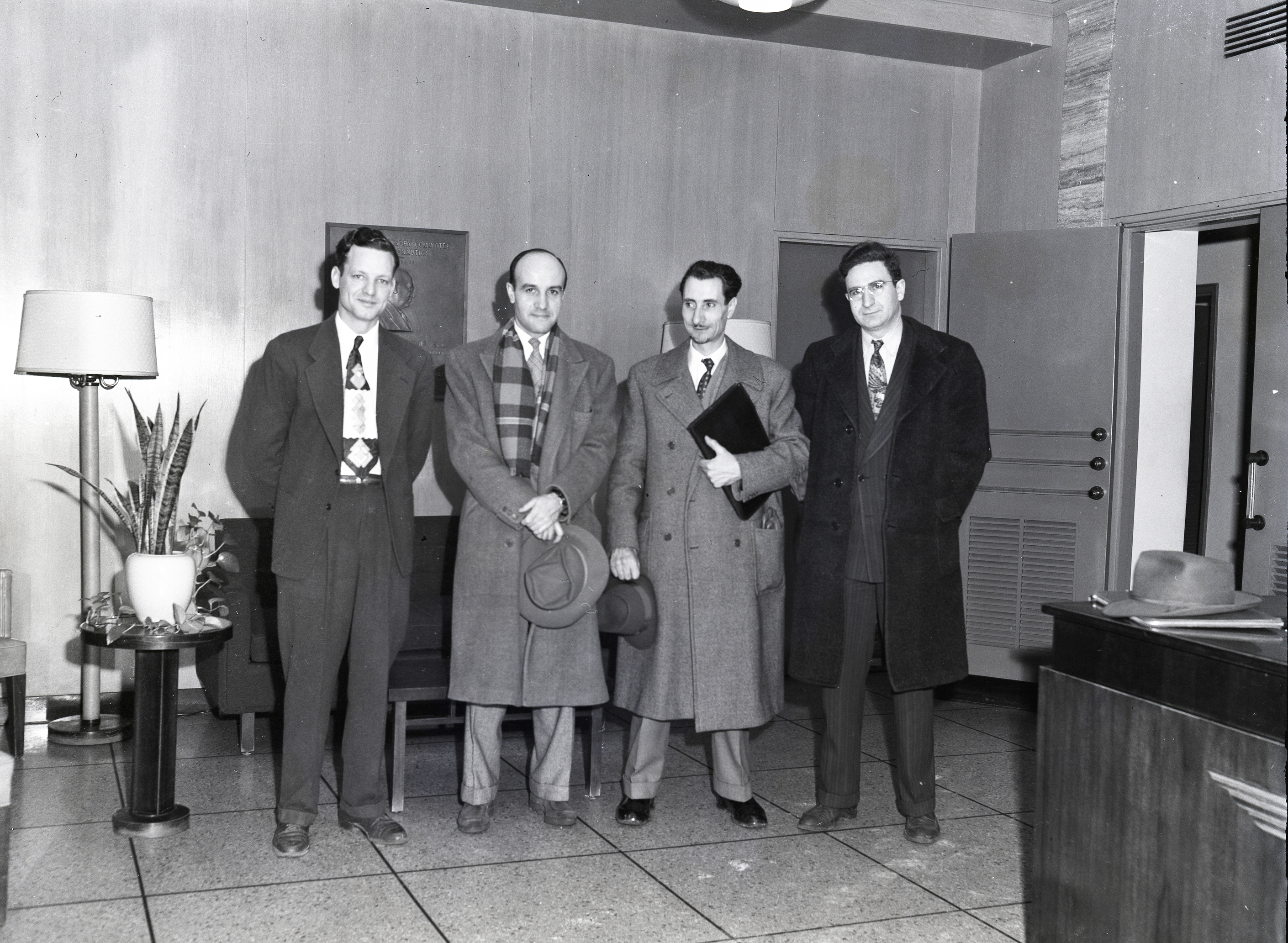 Four men standing in lobby.