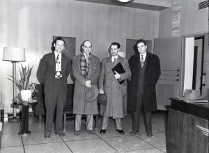 Four men standing in lobby.
