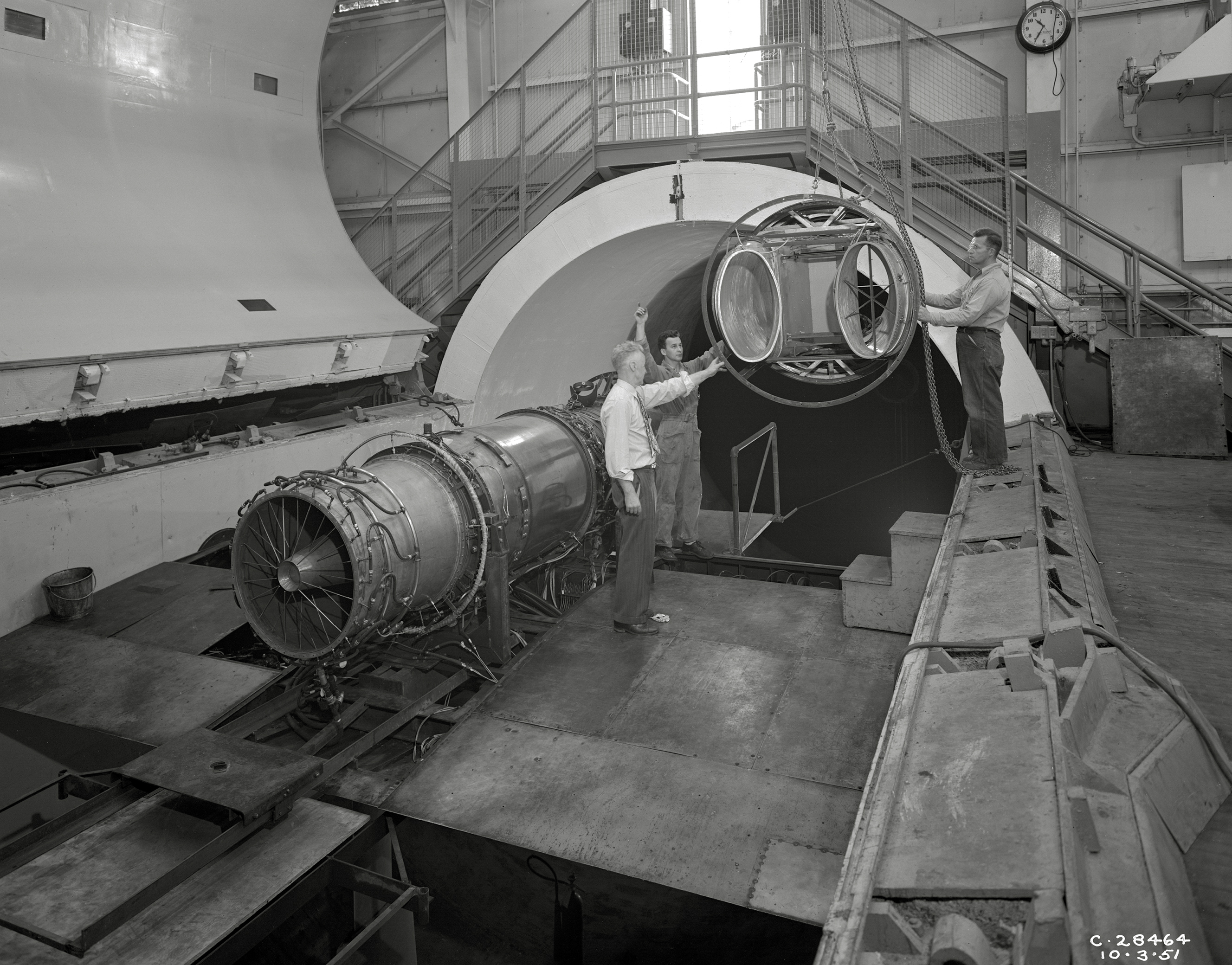 A rail crane lowers an inlet duct into the 20-foot diameter AWT test section