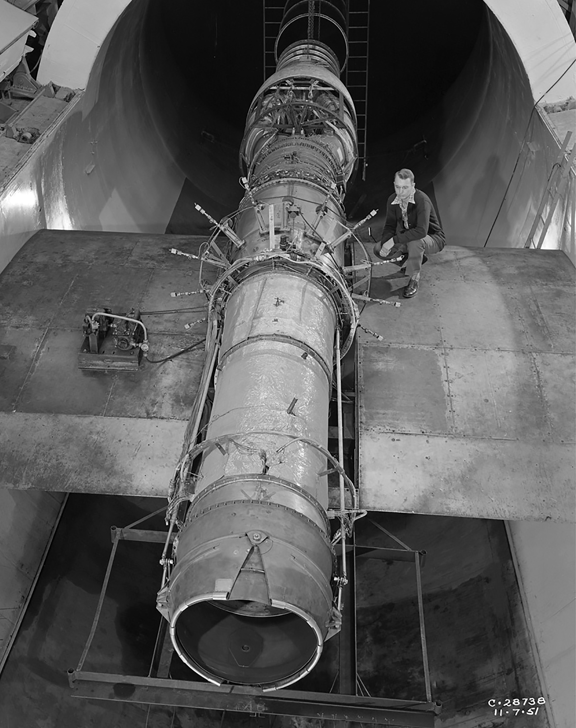Researcher on wing span examines J40 engine in test section