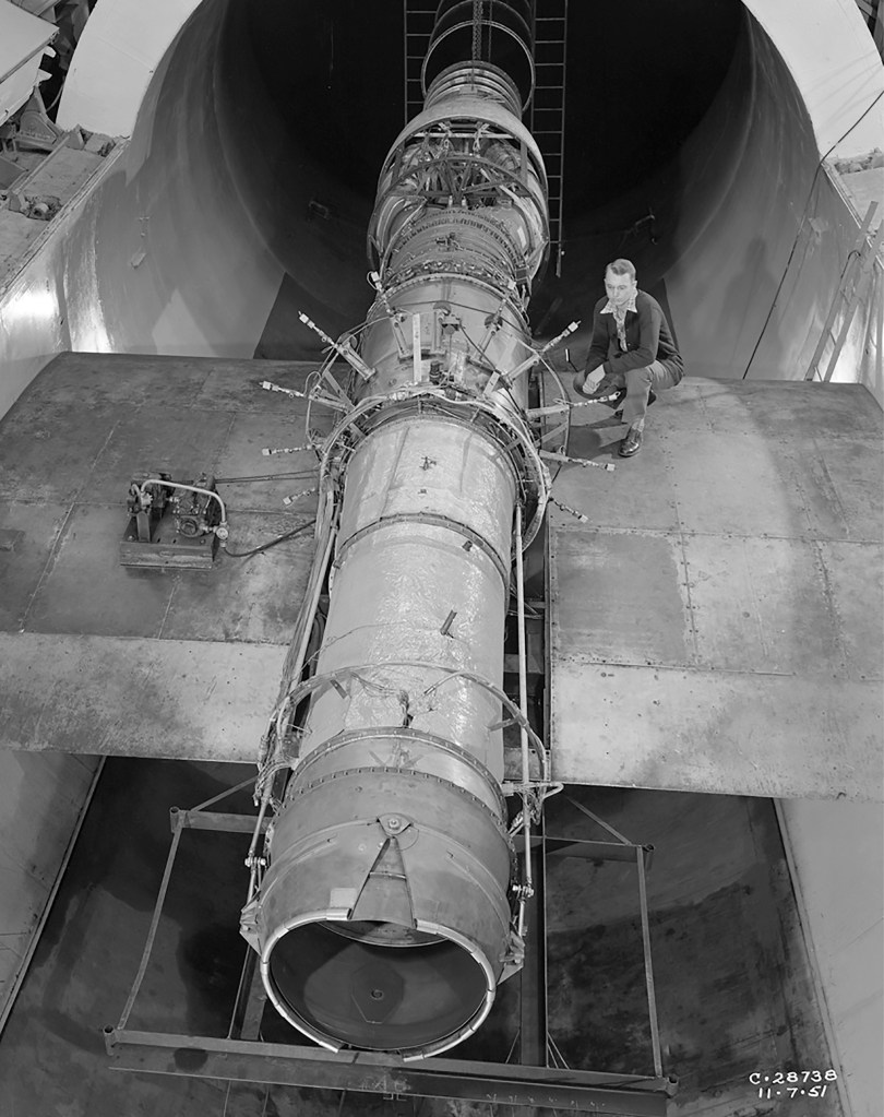 Researcher on wing span examines J40 engine in test section
